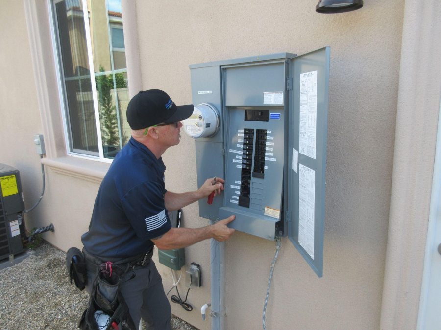 home inspector removing electrical panel for inspeciton