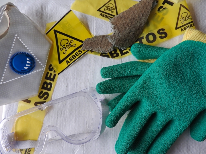 gloves, masks, goggles, and yellow asbestos tape laid out on table