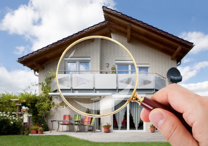 Magnifying glass over home signifying home inspection